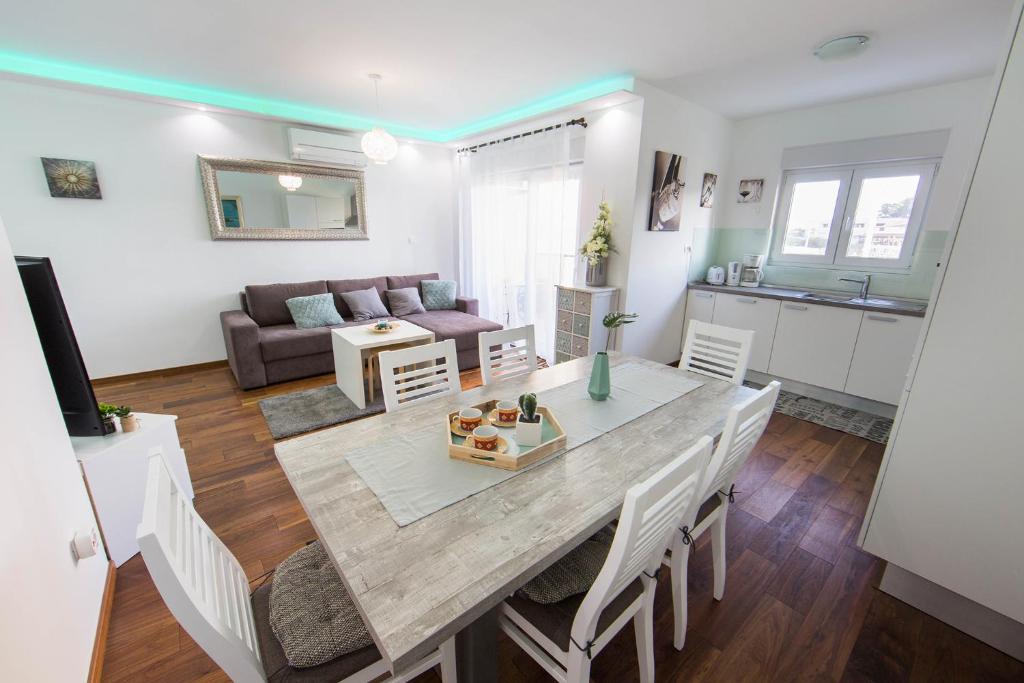 uma cozinha e sala de estar com mesa e cadeiras em Apartment's Tea & Nevio em Split
