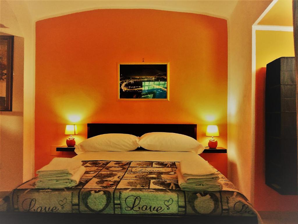 a bedroom with a bed with an orange wall at Da Zia Geppina in Naples