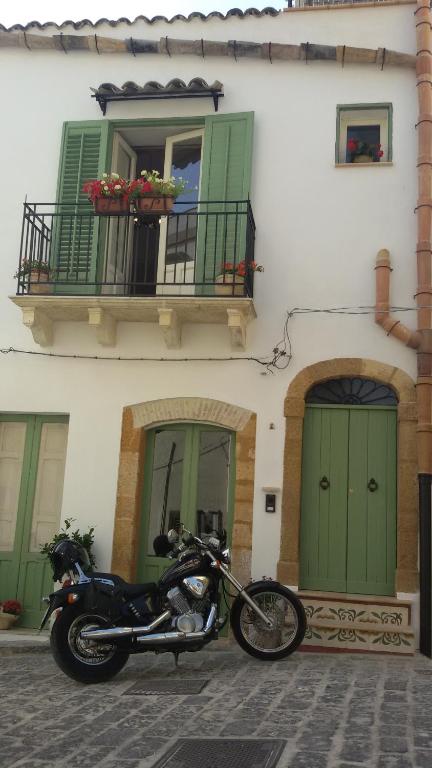 motocykl zaparkowany przed budynkiem z zielonymi drzwiami w obiekcie Le Stanze dell'Emiro w mieście Sambuca di Sicilia