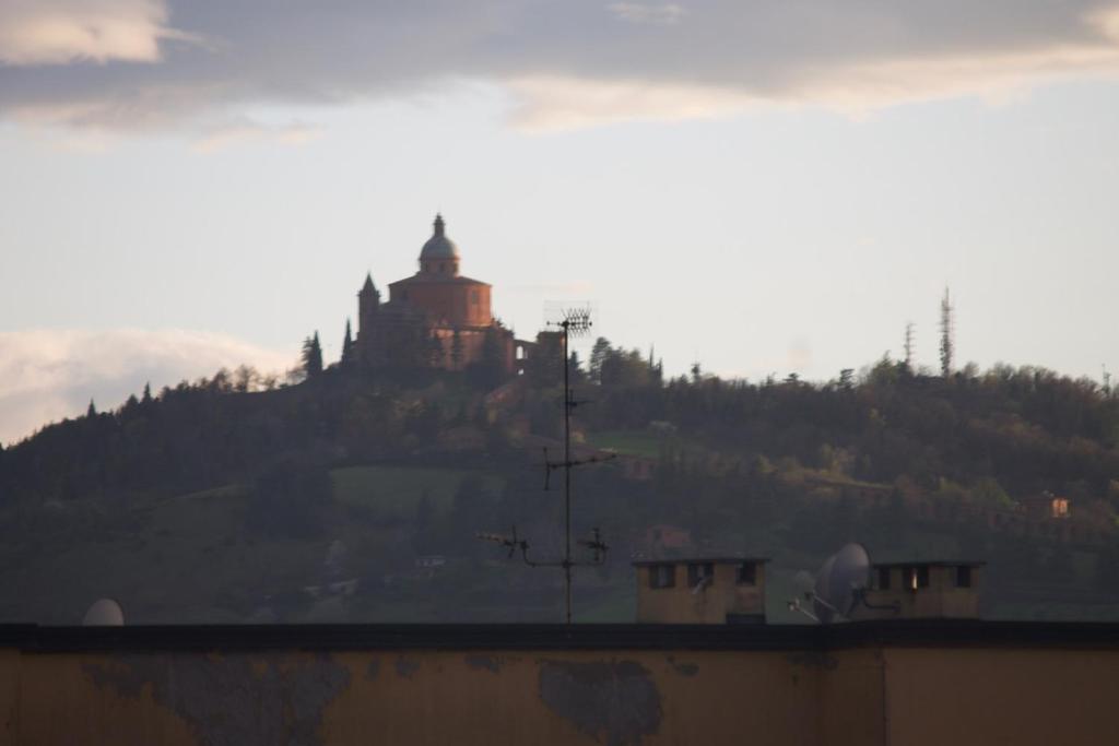 un bâtiment au sommet d'une colline avec un château dans l'établissement MyRoom CenterStation Bologna, à Bologne