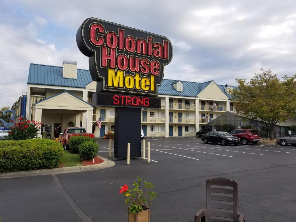 Um sinal de motel colombiano em frente a um parque de estacionamento. em Colonial House Motel em Pigeon Forge