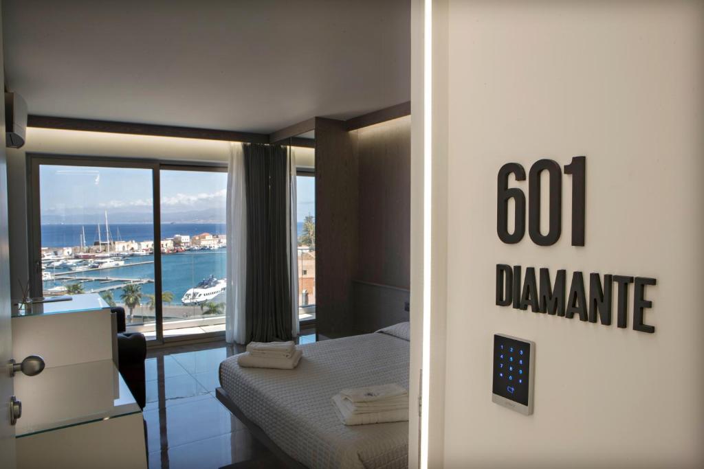 a hotel room with a bed and a view of the ocean at Upper - Boutique Hotel in Milazzo