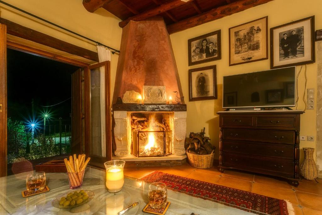 ein Wohnzimmer mit einem Kamin und einem TV in der Unterkunft Ifigenia Theriso Village in Thérison