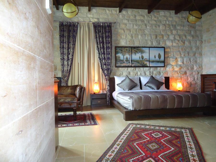 a bedroom with a king sized bed and a chair at Siena Hotel in Jounieh