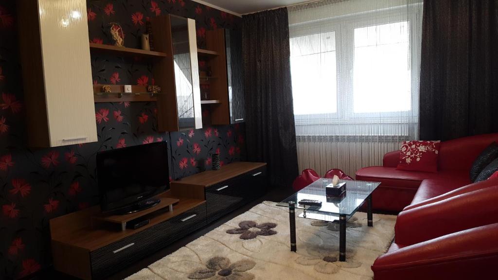 ein Wohnzimmer mit einem roten Sofa und einem TV in der Unterkunft Apartament Matei in Constanţa