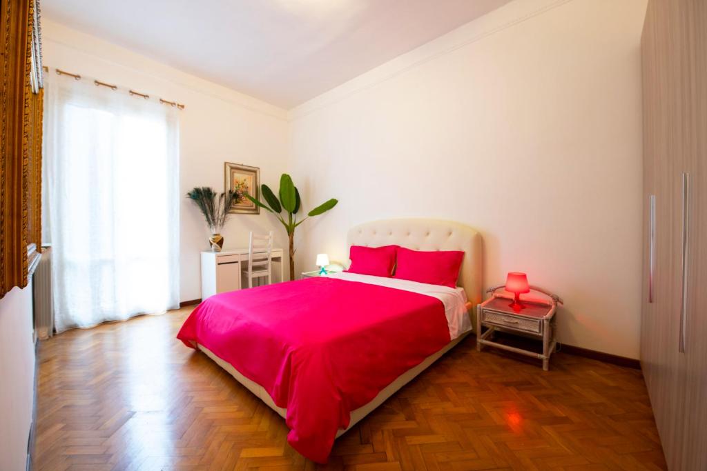 een slaapkamer met een groot bed en een rode deken bij Tiberim Apartment Trastevere 10 in Rome
