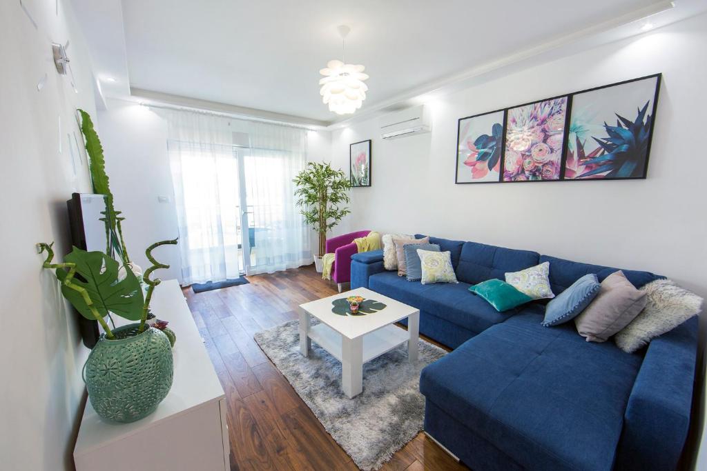 a living room with a blue couch and a table at Apartment Tina in Split