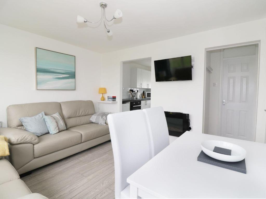 a white living room with a couch and a table at Sunbeach Chalets in Great Yarmouth