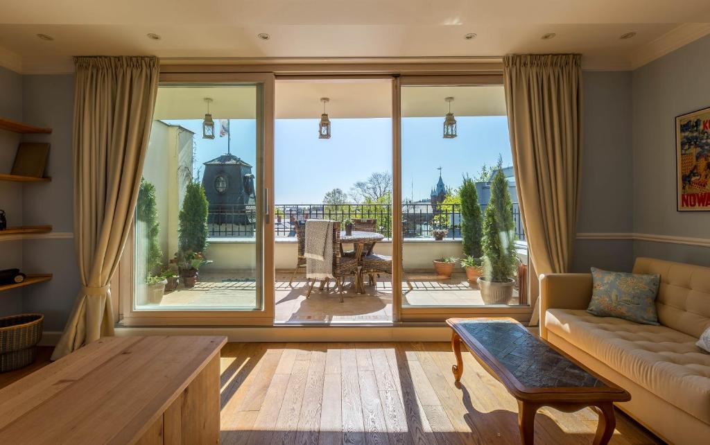 a living room with a couch and a large window at Fragola Apartments Old Town in Krakow