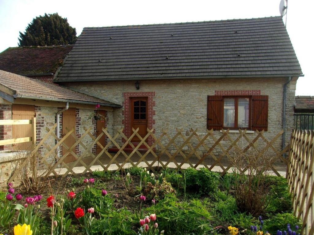 a house with a wooden fence in front of a garden at Gîte à la campagne in Cressonsacq