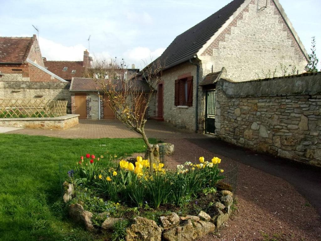 a garden in front of a stone building with flowers at Gîte à la campagne in Cressonsacq