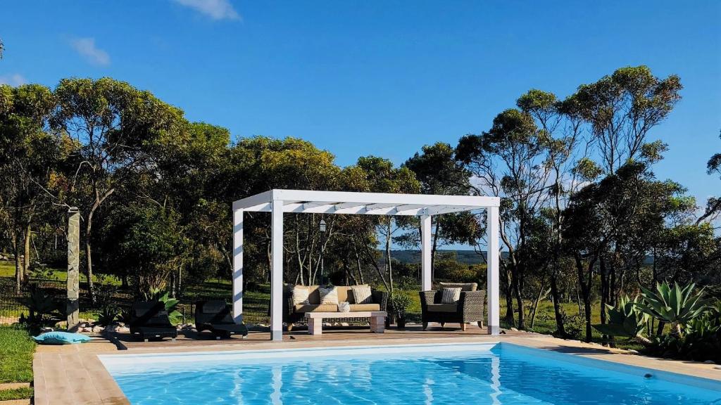 uma piscina com um gazebo, um sofá e acessórios em Herdade Monte Do Sol em Aljezur