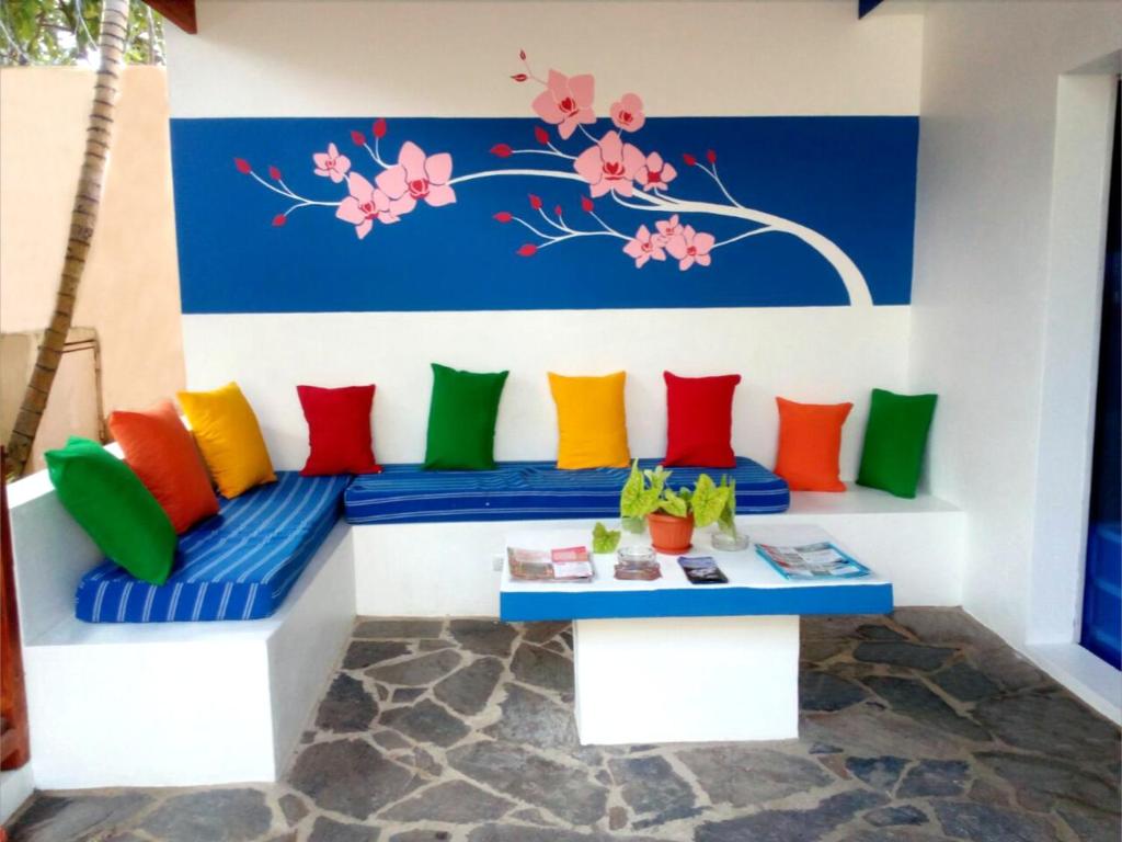 a bench with colorful pillows and a table at House Jardin Del Caribe in Las Terrenas