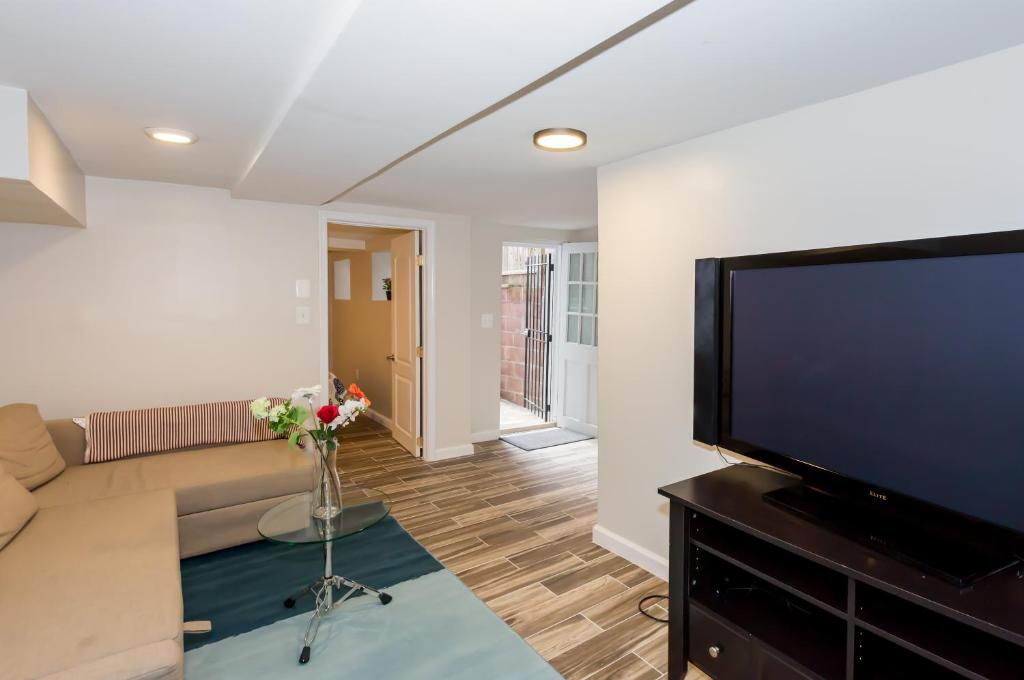 een woonkamer met een bank en een flatscreen-tv bij 2 Full Bedrooms Basement Apt; 3-Min Walk To Petworth Metro; in Washington