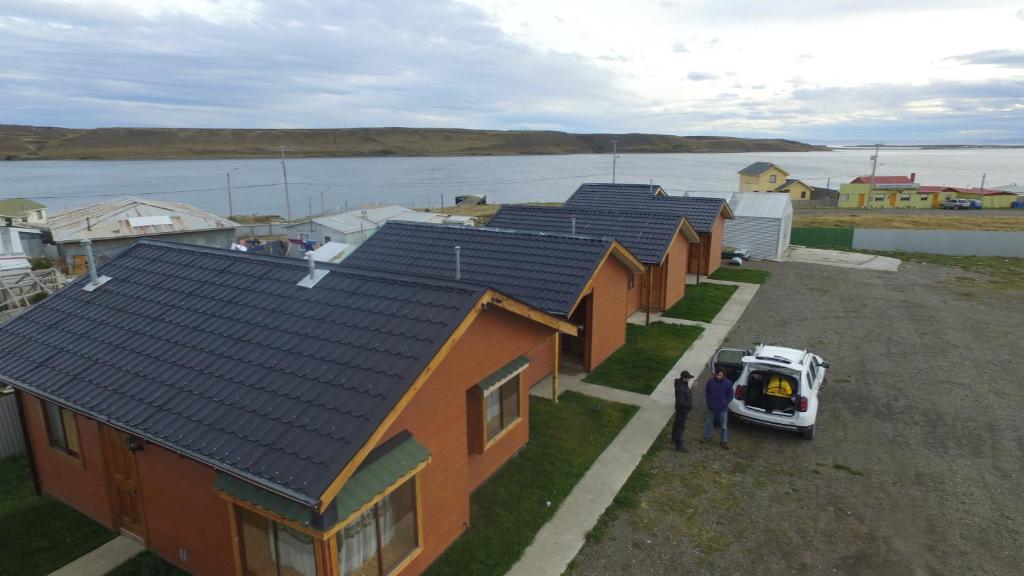 eine Gruppe von Häusern mit einem Van vor dem Haus in der Unterkunft Cabañas Pulegan in Porvenir