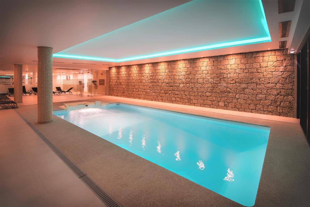 una grande piscina in un hotel con illuminazione blu di Flag Hotel Celorico Palace a Celorico de Basto