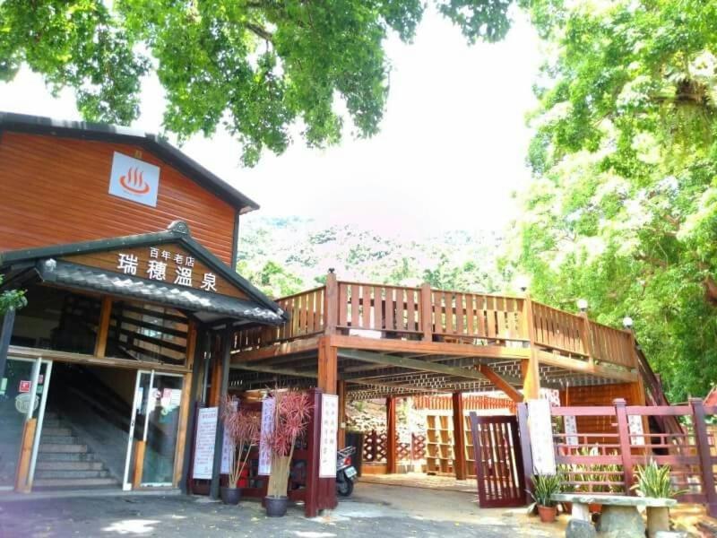 um edifício de madeira com um deque no topo em JS Hotspring em Ruisui