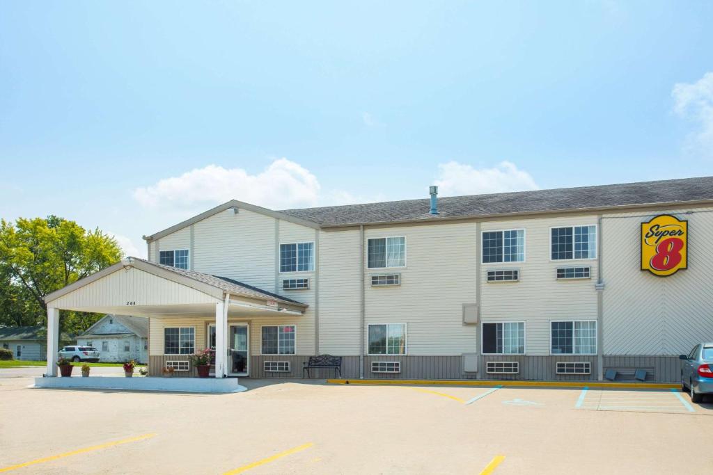 a large white building with a fast food restaurant at Super 8 by Wyndham Sweet Springs in Sweet Springs