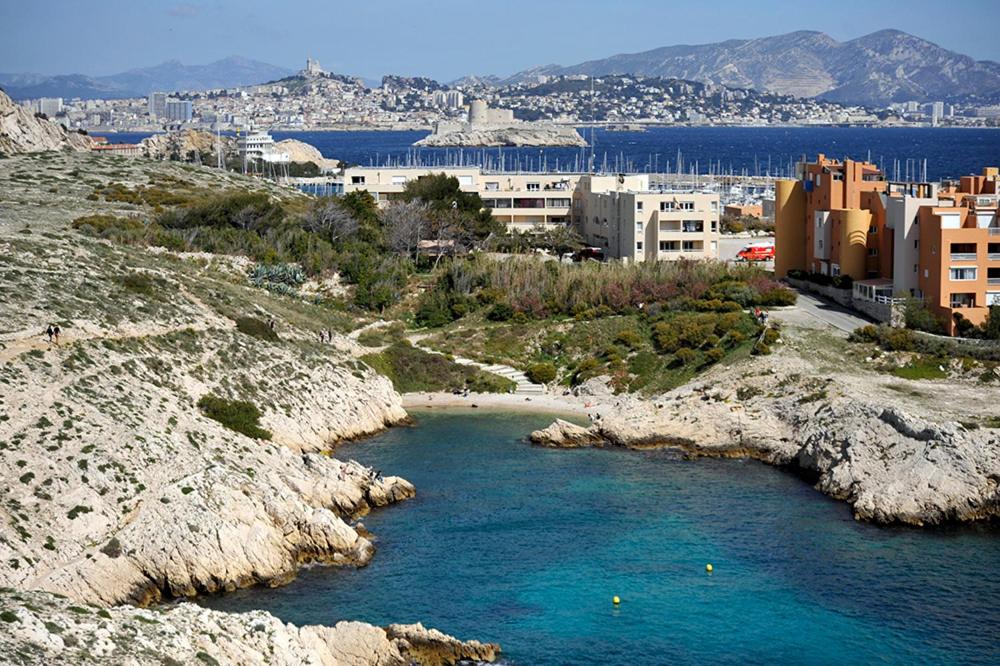 ein Wasserkörper mit einer Stadt im Hintergrund in der Unterkunft le friouli in Marseille