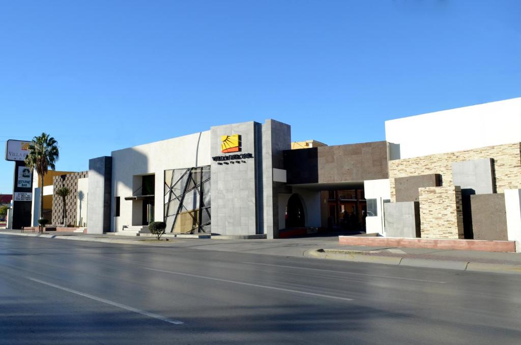 un bâtiment situé sur le côté d'une rue dans l'établissement Hotel Villa del Sol, à Ciudad Juárez