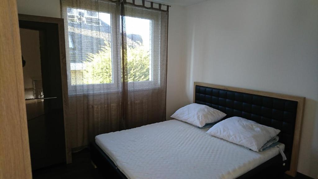 um pequeno quarto com uma cama e uma janela em King23 em Siófok