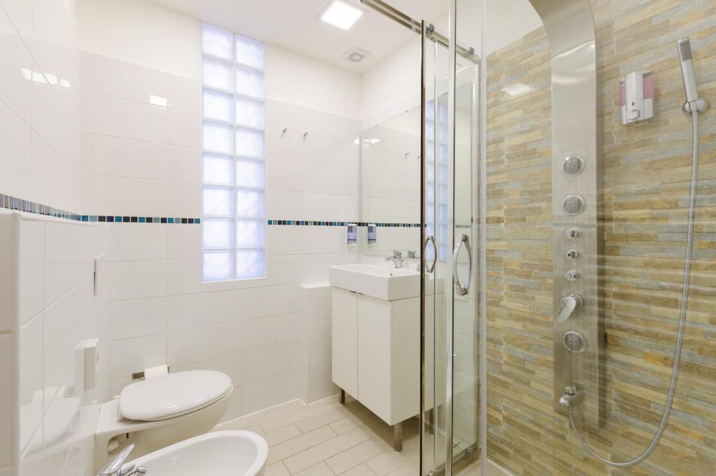 a bathroom with a shower and a toilet and a sink at Hotel Viking in Rimini