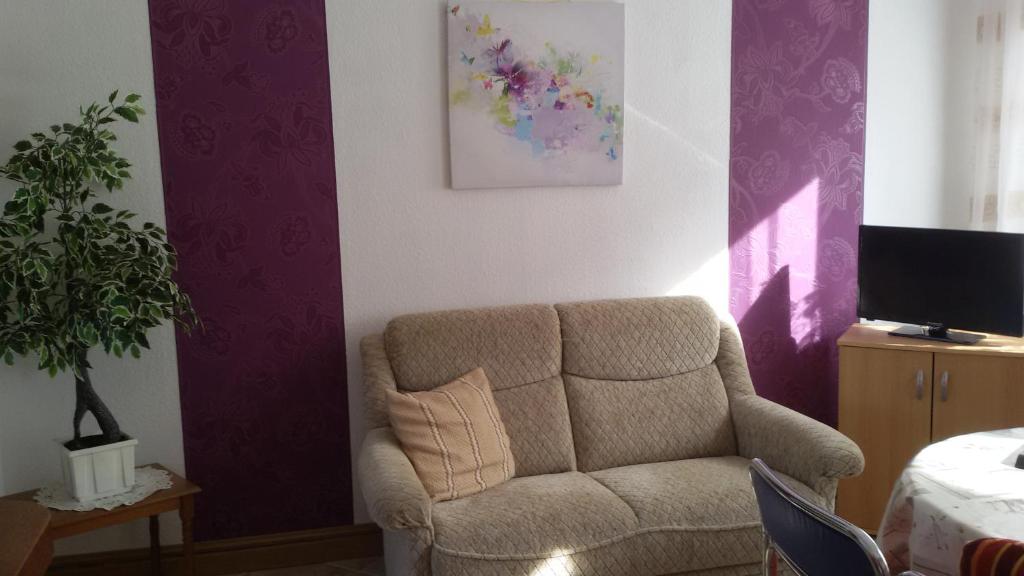 sala de estar con silla y sofá en Wendler`s Haus, en Meuselwitz