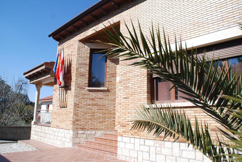 une maison en brique avec un drapeau sur son côté dans l'établissement Casa Rural Mirando a Gredos, à Cadalso de los Vidrios