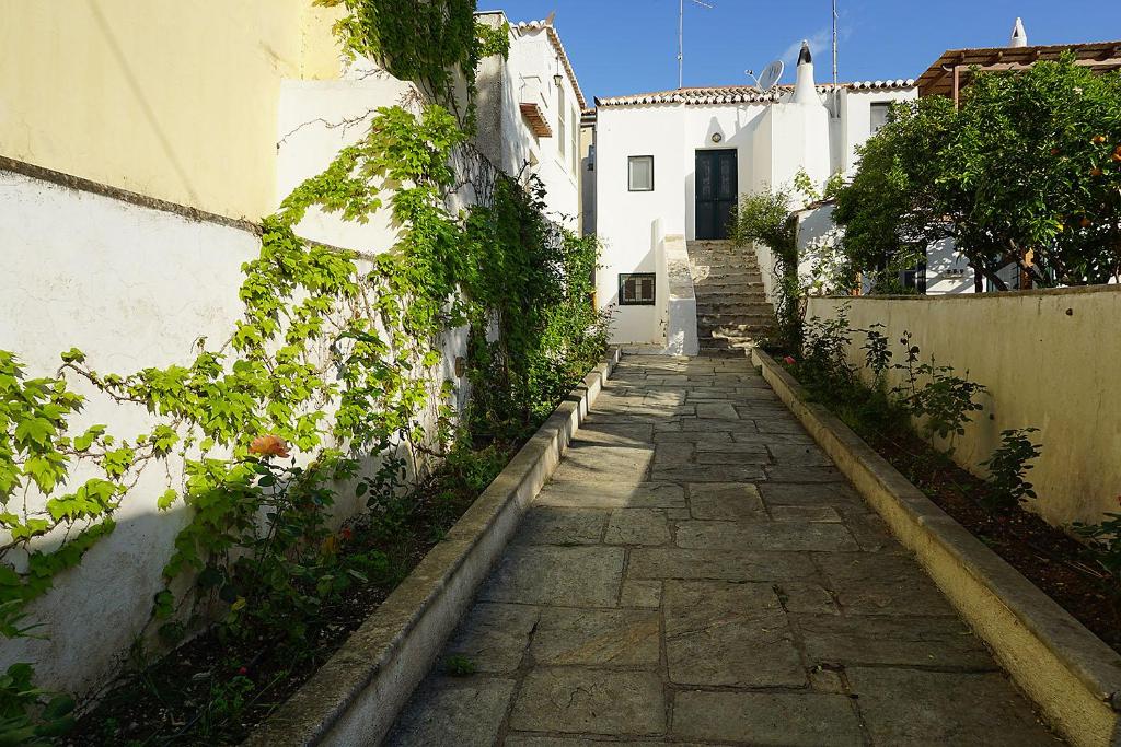 un camino de piedra frente a un edificio blanco en Two Olive Trees, en Spetses