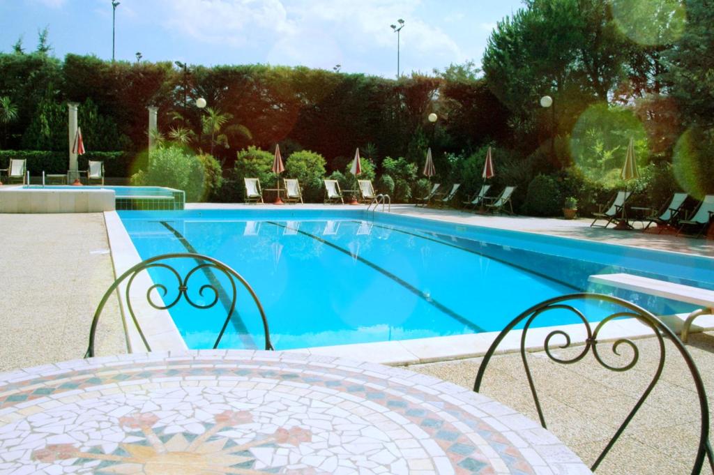 ヴィエステにあるResidence Villa Agrimareのテーブルと椅子が隣接するスイミングプールを利用できます。