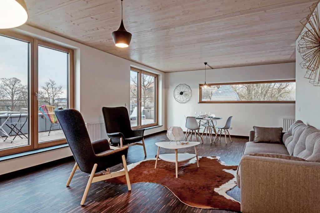 een woonkamer met een bank, stoelen en een tafel bij Vistay apartments in Luxemburg