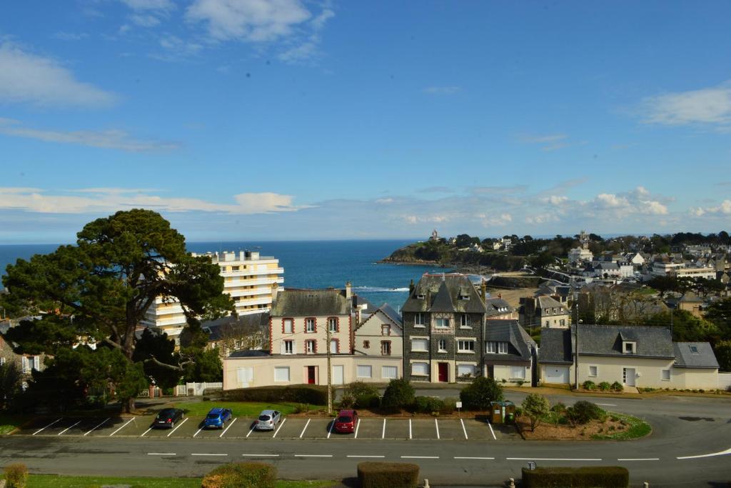 Une ville avec des maisons et l'océan en arrière-plan dans l'établissement Kerwelmor, appartement avec vue sur la mer, à Saint-Quay-Portrieux