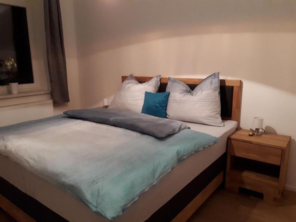 Oberwirt في Lambrechten: غرفة نوم مع سرير ووسائد زرقاء وبيضاء