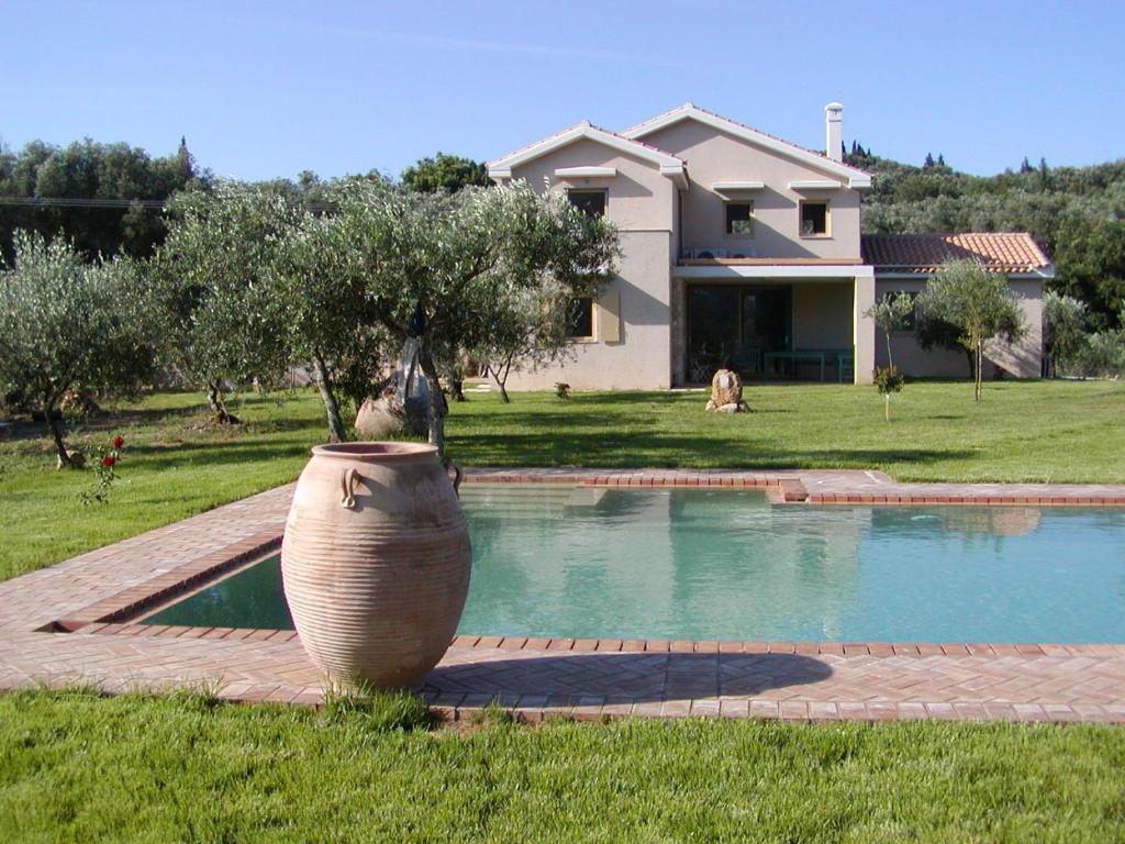 un jarrón grande sentado frente a una casa en Olive Áno Korakiána, en Áno Korakiána