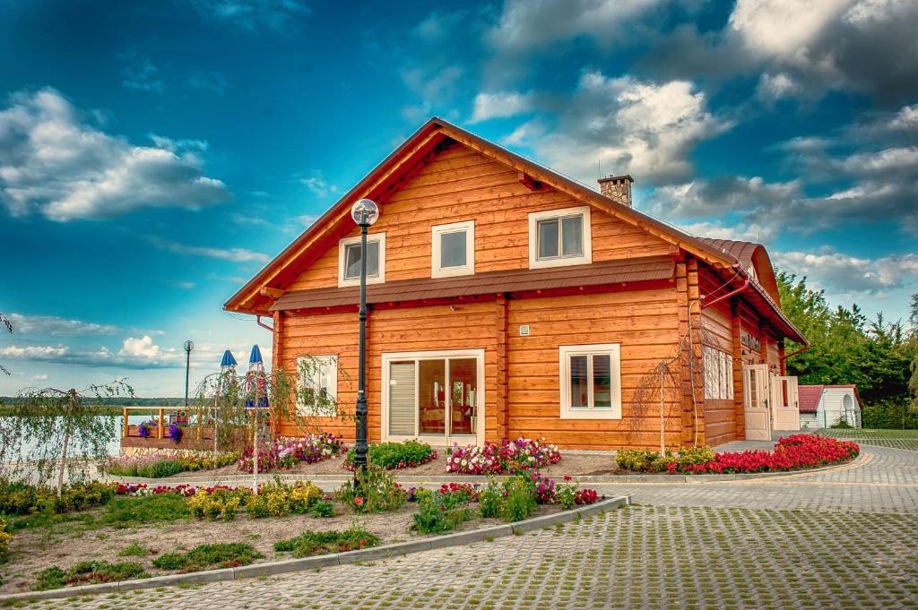 drewniany dom z kwiatami przed nim w obiekcie Rybaczówka Karczma Rybna w Świnoujściu