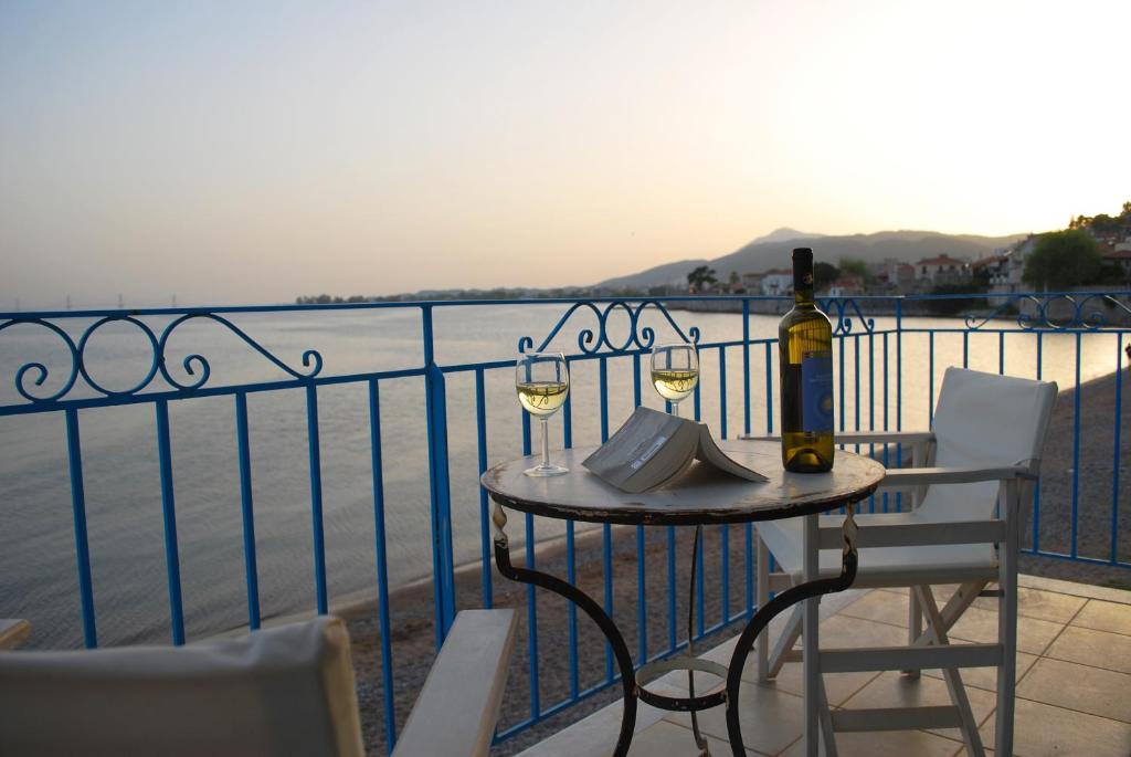 einen Tisch mit zwei Gläsern Wein auf dem Balkon in der Unterkunft Villa "Pietra e Mare" in Nafpaktos