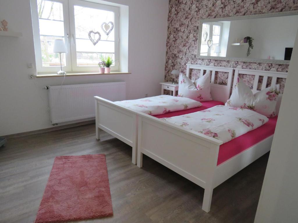 ヴィルヘルムスハーフェンにあるDaisys Ferienwohnung 68のベッドルーム1室(白いベッド1台、窓2つ付)