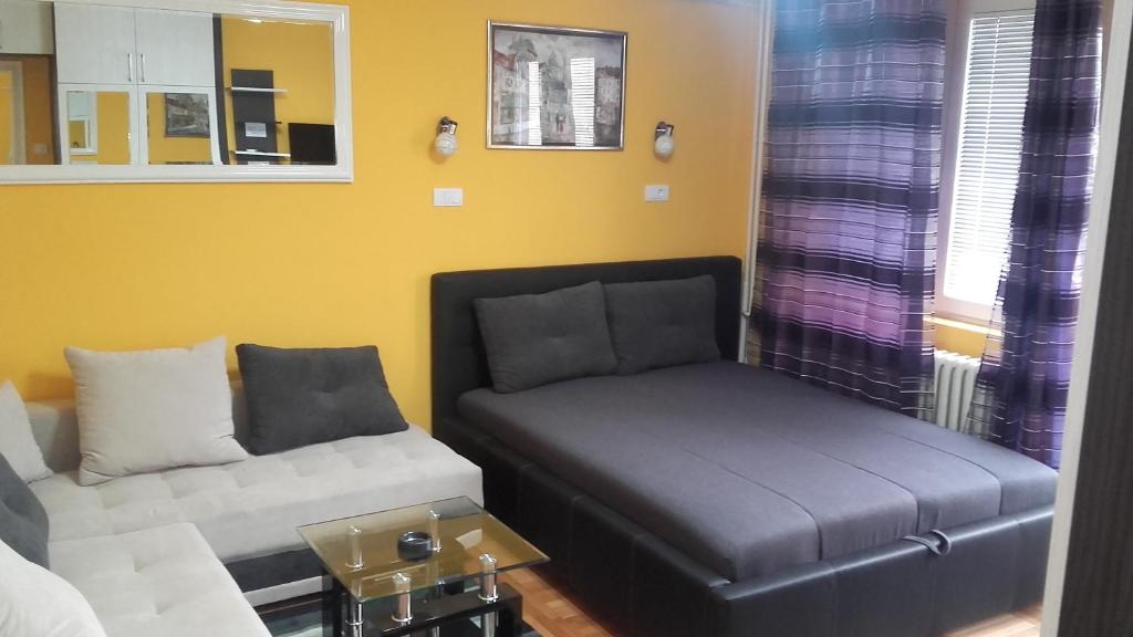 ein Wohnzimmer mit einer Couch und einem Ottomanen in der Unterkunft House Prljevic in Užice