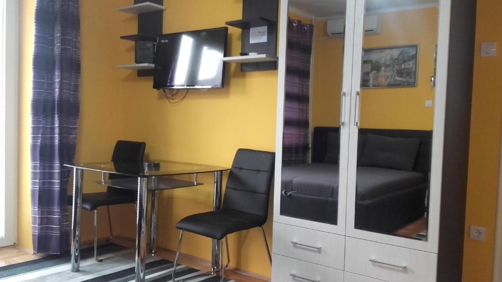 Zimmer mit einem Tisch, Stühlen und einem Spiegel in der Unterkunft House Prljevic in Užice