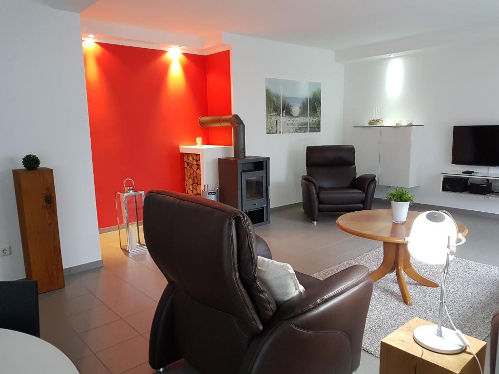 a living room with a black chair and a table at dat witte hus 1 in Büsum