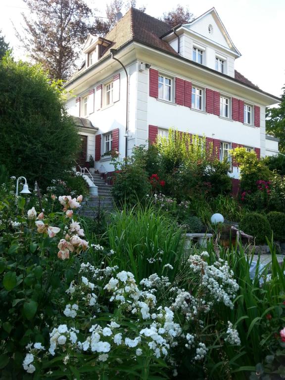a garden in front of a house with flowers at B&B Rosenliebe in Niedereschach
