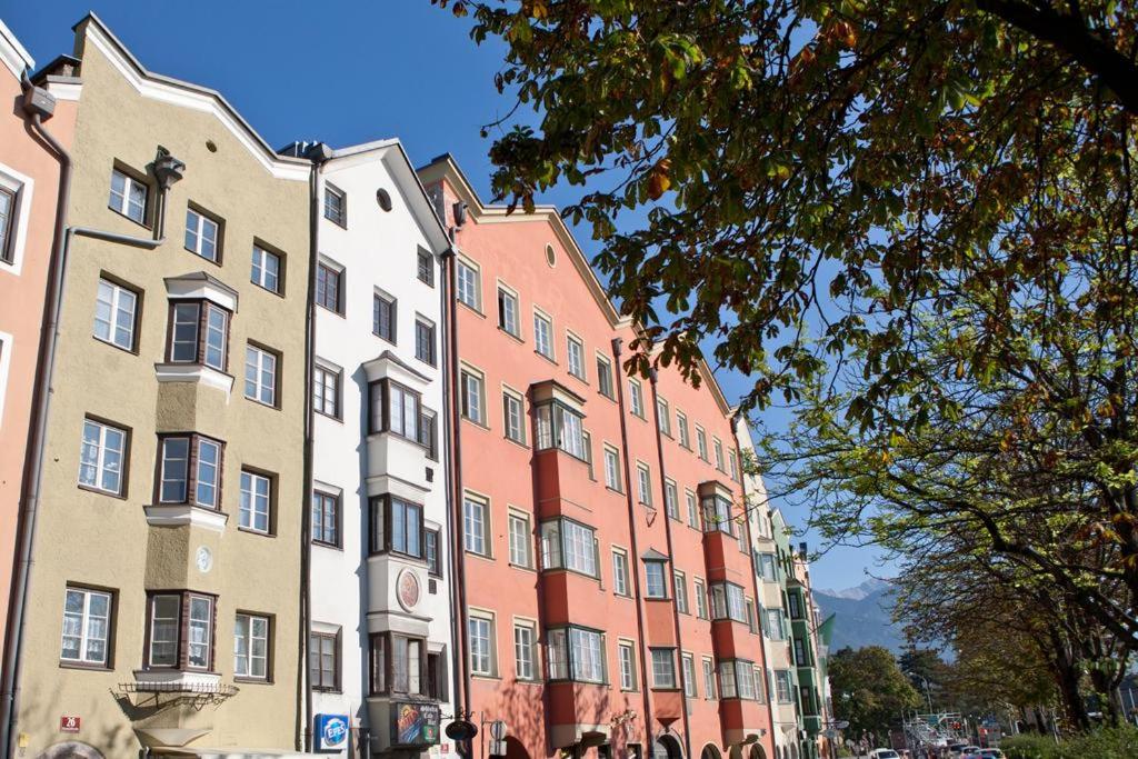 una fila de edificios con gente caminando delante de ellos en Apartment Maximilian in old Town en Innsbruck