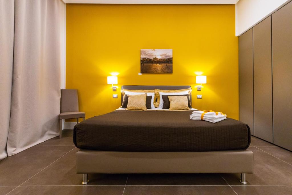 ナポリにあるN'apartmentのベッドルーム1室(黄色い壁のベッド1台付)