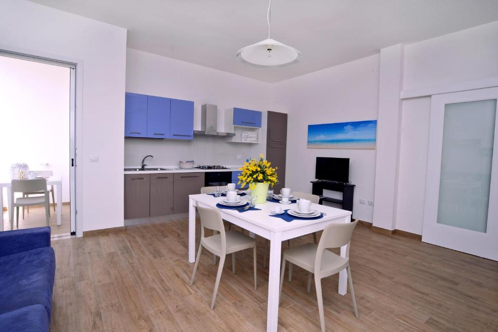 a kitchen and dining room with a white table and chairs at Altomare Case Vacanza in Porto Cesareo