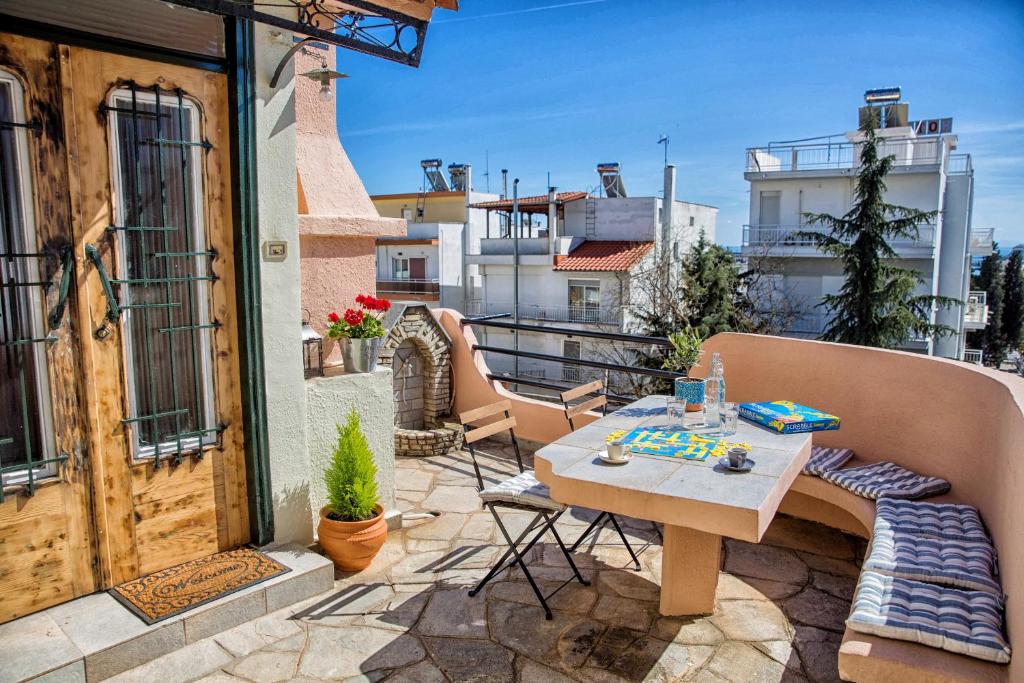 a patio with a table and chairs on a balcony at The Old Salt in Kavala