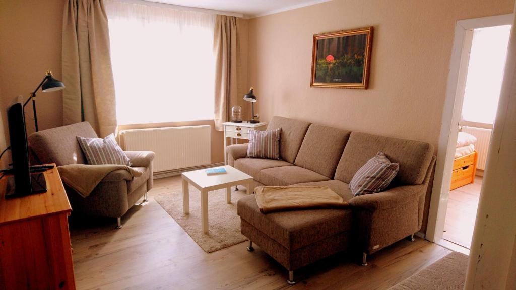 ein Wohnzimmer mit 2 Stühlen, einem Sofa und einem Tisch in der Unterkunft house46-1 in Hohen Neuendorf