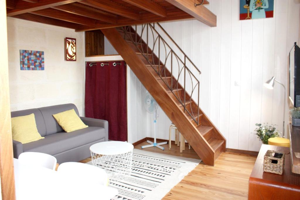 a living room with a couch and a staircase at Le Grand-Victoire, Centre-Ville - Parking Gratuit in Bordeaux