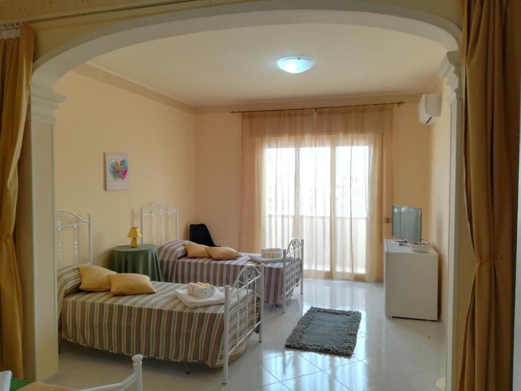 a living room with two beds and a television at Lolita Studios in Marsala