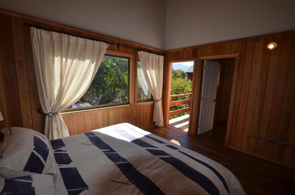 una camera da letto con un letto e una grande finestra di Cabañas Las Cabras a Las Trancas