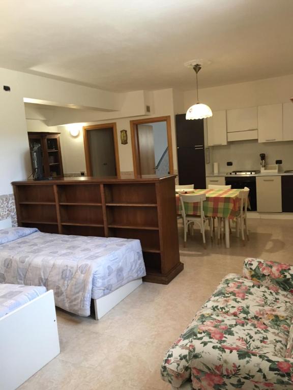 a bedroom with two beds and a table and a kitchen at A Villafontana in Bovolone